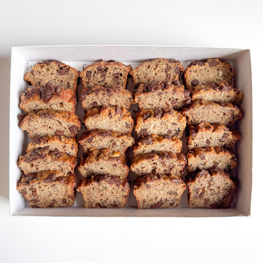 Sliced mini banana bread with chocolate chips arranged in a white box.