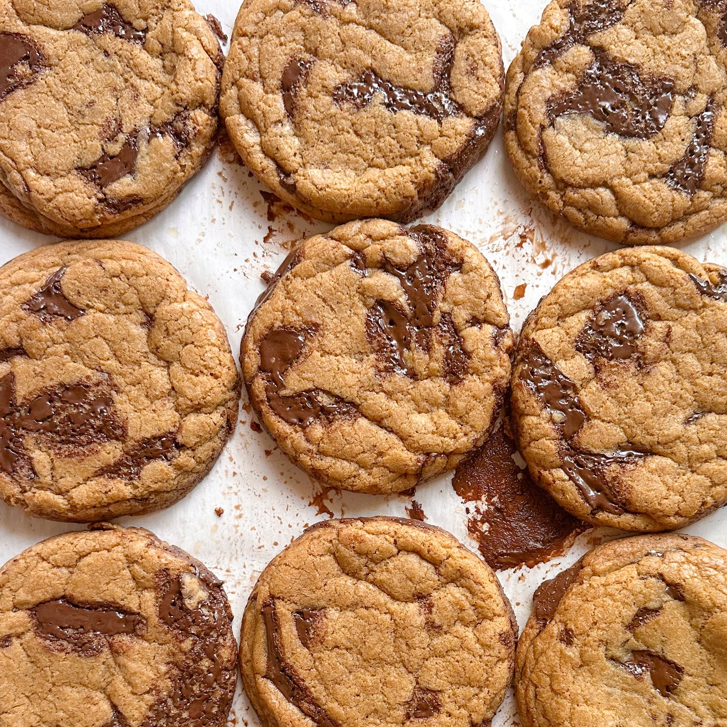 Gooey chocolate chip cookies with big chocolate chunks on a white tray.